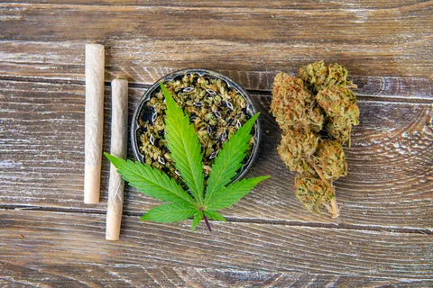 Kräutermischung im Grinder mit Joints und Hanfblatt